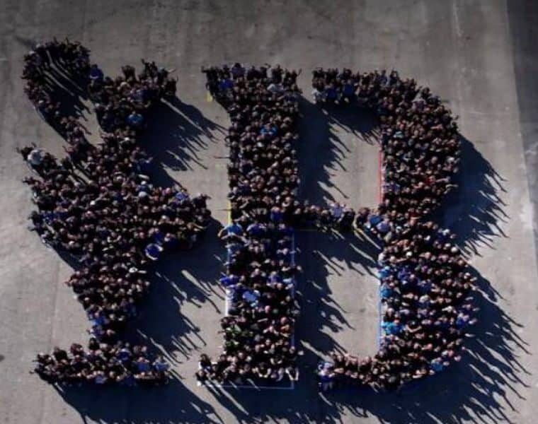 800 voluntarios crean un mosaico humano con el logo de la Copa América de Vela en Barcelona